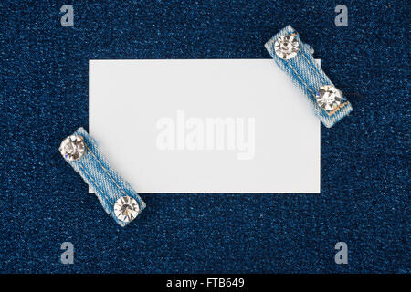 Business card con due cinghie jeans con strass, giace sul denim, con spazio per il testo Foto Stock