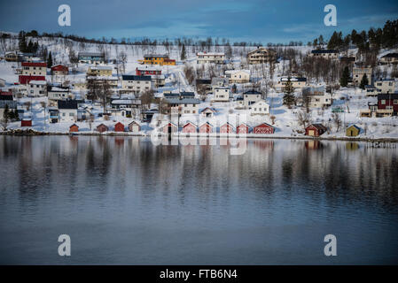 Barca Rossa con case a lato di un fiordo vicino a Tromso, Norvegia. Foto Stock