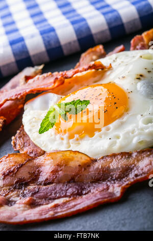 Prosciutto e uova. Uova e pancetta. Uovo salato e cosparsi di pepe nero. Prima colazione inglese. Foto Stock