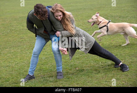 Adolescenti che giocano a pressione e spinta gioco in un parco Foto Stock