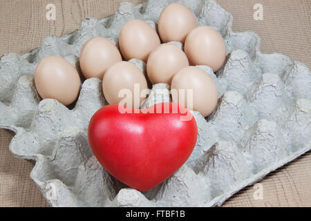 Cuore e uova sul pannello di carta e modello di carta il legno Foto Stock