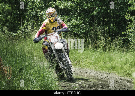 Driver di Motocross sul bagnato e fangoso terreno compete durante la gara di coppa di Ural di Enduro Foto Stock