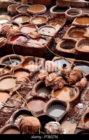 Un lavoratore marocchino coloranti a mano le pelli di animali con i serbatoi riempiti con i colori alla conceria Chouara all'interno del cuoio Souq Aprile 26, 2009 in Fez, in Marocco, Venerdì, 20 giugno 2014. L'antica Conceria ha operato a partire dal XI secolo e continua ad utilizzare le tecniche tradizionali e coloranti. Foto Stock