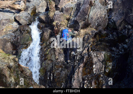 Giovane uomo rampicante delle cascate in Stickle Ghyll in Langdale,Cumbria Regno Unito. Foto Stock