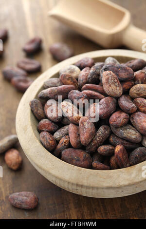 Materie cacao cacao in grani nella ciotola di legno Foto Stock