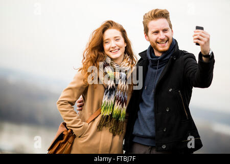 Vista della coppia giovane tenendo selfie all'aperto Foto Stock