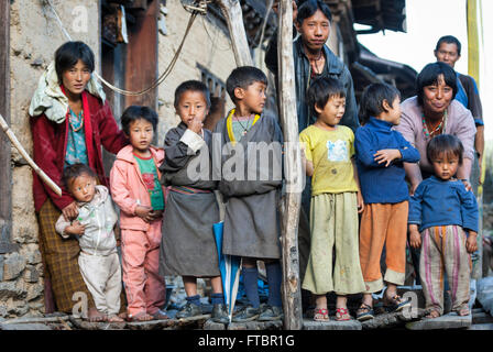 Un gruppo di bambini che sono schierate dai loro genitori per un ritratto in villaggio Korphu, southern Bhutan Foto Stock