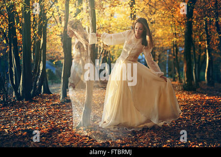 Bella donna dancing in autunno boschi. Surreale e romantico Foto Stock