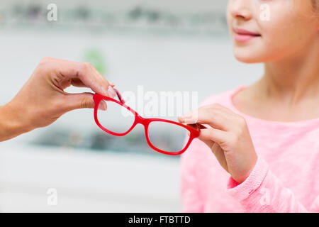 Close up girl tenendo bicchieri al negozio di ottica Foto Stock