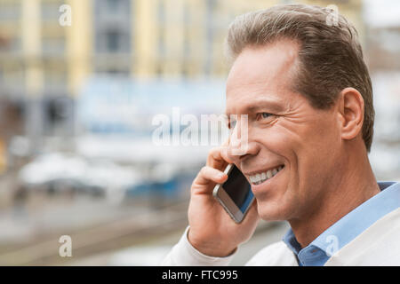 Allegro uomo parlando al telefono cellulare Foto Stock