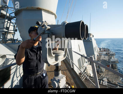 150514-N-FQ994-172 Mare Mediterraneo (14 maggio 2015) Boatswain compagno del marinaio Hugo Saenz, da Chicago, i colleghi attraverso il binocolo nave a bordo della USS Ross (DDG 71) Maggio 14, 2015. Ross, un Arleigh Burke-class guidato-missile distruttore, distribuita a Rota, Spagna, sta conducendo operazioni navali negli Stati Uniti Sesta flotta area di operazioni a sostegno degli Stati Uniti per gli interessi di sicurezza nazionali in Europa. (U.S. Foto di Marina di Massa lo specialista di comunicazione di terza classe Robert S. Prezzo/rilasciato) Foto Stock