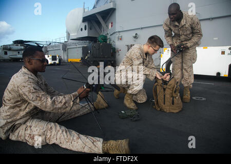 Oceano Indiano (Luglio 23, 2015) DEGLI STATI UNITI Marines con sede e società di assistenza, Battaglione Team di atterraggio 3° Battaglione, 1° Reggimento Marine,xv Marine Expeditionary Unit (MEU), testare la loro tv radio sul ponte di volo dell'assalto anfibio nave USS Essex (LHD 2). Elementi del XV MEU, basato fuori di Camp Pendleton, California, e imbarcato a bordo dell'Essex, stanno conducendo operazioni militari nella sesta flotta area di operazioni a sostegno degli Stati Uniti per gli interessi di sicurezza nazionali in Europa e in Africa. (U.S. Marine Corps foto di Cpl. Anna Albrecht/ rilasciato) Foto Stock