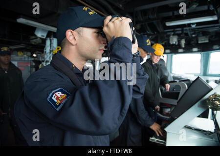 150921-N-XG464-022 OCEANO ATLANTICO (sett. 21, 2015) Ensign Michael de La Pietra, dalla Ardsley, New York, le ricerche per le altre navi di superficie permanente, mentre guarda a bordo della USS Carney (DDG 64) sett. 21, 2015. USS Carney, un Arleigh Burke-class guidato-missile distruttore, sta conducendo operazioni navali negli Stati Uniti Sesta flotta area di operazioni a sostegno degli Stati Uniti per gli interessi di sicurezza nazionali in Europa. (U.S. Foto di Marina di Massa lo specialista di comunicazione di terza classe Jonathan B. Trejo/rilasciato) Foto Stock