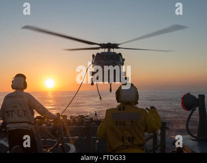 151003-N-TC720-431 mare mediterraneo (ott. 3, 2015) di Boatswain Mate 2a classe Beyontee Carter, da Chicago, dirige un MH-60R elicottero assegnato al mare in elicottero Combat Squadron 28 (HSC 28) durante un rifornimento in mare addestramento di volo con USS Donald Cook (DDG 75) Ottobre 3, 2015. Donald Cook, un Arleigh Burke-class guidato-missile distruttore, distribuito a Rota, Spagna, sta conducendo una pattuglia di routine negli Stati Uniti Sesta flotta area di operazioni a sostegno della sicurezza nazionale USA interesse in Europa. (U.S. Foto di Marina di Massa lo specialista di comunicazione di terza classe Mat Marzo/rilasciato) Foto Stock