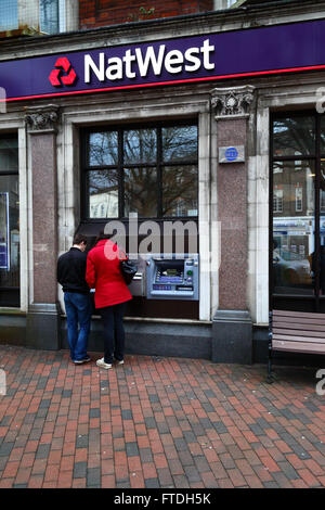 Coppia che usa la cassa della banca NatWest / ATM su High Street, Tonbridge , Kent, Inghilterra Foto Stock