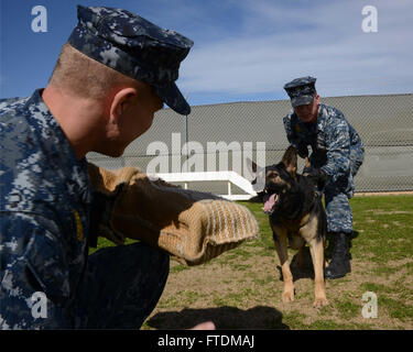 Il 12 febbraio 2016, il Master-at-Arms Michael Langehennig e Matthew Hollingsworth condussero un addestramento di aggressione controllato con il cane militare Gerry alla Naval Support Activity Souda Bay. Gli MMD sono essenziali per il rilevamento di esplosivi e narcotici. Foto Stock