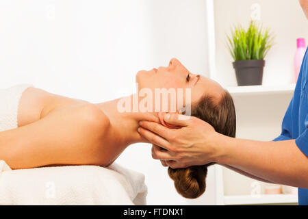 Massaggiatore facendo massaggio collo sulla donna in spa salone Foto Stock