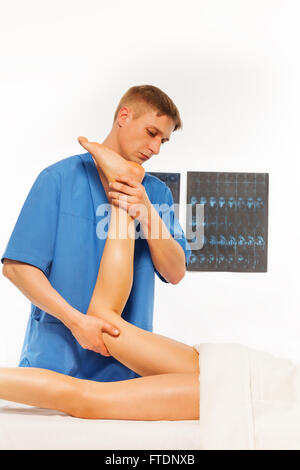 Fisioterapista facendo massaggi sulla gamba donna Foto Stock