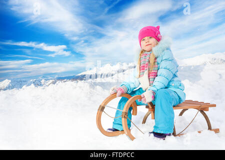 Felice bambina in blu sulla slitta Foto Stock