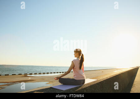 Giovane donna giapponese la pratica dello yoga in un parco della città Foto Stock