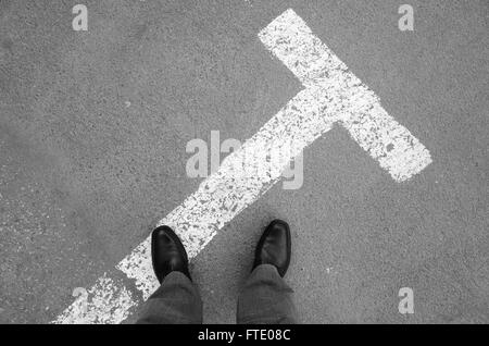 Urbanite man in black nuovi fulgidi scarpe di cuoio in piedi su asfalto con parcheggio la segnaletica stradale Foto Stock