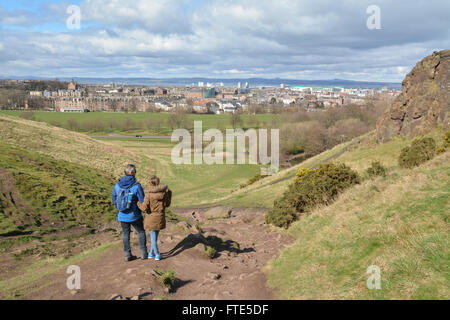 Due persone godendo di una vista di Edimburgo in primavera come essi a piedi verso il basso a partire da Arthur' Seat in Holyrood Park Foto Stock