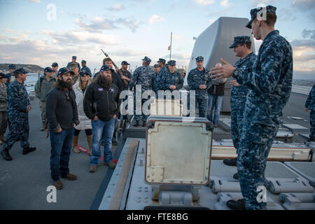 SOUDA BAY, Grecia (dec. n. 07, 2013) - Da bombardieri Mate 2a classe Marc Hibner, destra, Fire Controlman 2a classe Joshua Gonzalez Mostra 'Duck Dynasty' stelle Jep, sinistra e Willie Robertson, a sinistra della verticale del sistema di lancio (VLS) a bordo del Arleigh Burke-class guidato-missile destroyer USS Stout (DDG 55). La dimostrazione è parte dell'annuale OSU tour vacanza, che dispone di una varietà di altre celebrità e il Presidente del Comune di capi di Stato Maggiore visitando le basi e le navi a interagire con l'equipaggio per le vacanze. Stout, homeported a Norfolk, Virginia, è su una distribuzione programmata mariti di supporto Foto Stock