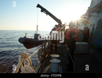 Questa immagine mostra i marinai a bordo del cacciatorpediniere missilistico guidato USS Ramage (DDG 61) che issano un gommone a scafo rigido l'8 febbraio 2014, in preparazione delle operazioni di trasferimento passeggeri nel Mar Mediterraneo. La USS Ramage fa parte delle operazioni della US Navy nella 6th Fleet. Foto Stock