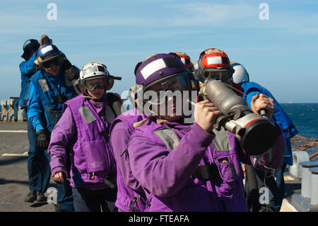 I marinai a bordo della USS Arleigh Burke (DDG 51) ritraggono una manichetta dopo aver rifornito un elicottero MH-60R Sea Hawk sul ponte di volo. Il cacciatorpediniere sostiene le operazioni di sicurezza marittima durante il suo dispiegamento nel Mediterraneo. Foto Stock