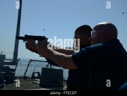 I marinai sulla USS Ramage (DDG 61), una nave della US Navy, effettuano una qualifica con armi da fuoco con pistole 9 mm sul ponte di volo durante un dispiegamento a sostegno delle operazioni di sicurezza marittima. Foto Stock