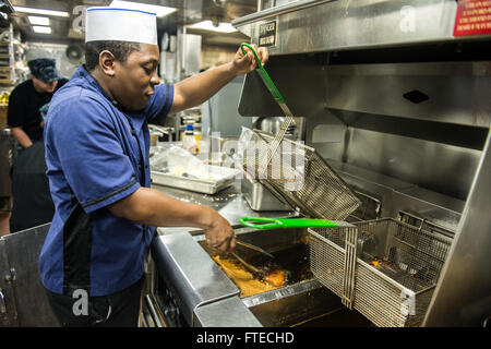 Lo specialista culinario Seaman Donell Dobbs prepara i pasti per l'equipaggio a bordo della USS Donald Cook (DDG 75), un cacciatorpediniere della classe Arleigh Burke schierato in avanti. La nave fa parte degli sforzi di difesa missilistica balistica della Marina degli Stati Uniti in Europa. Foto Stock