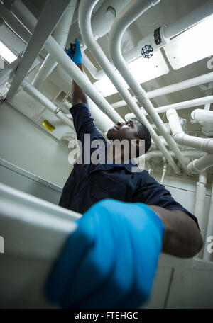 Mare Mediterraneo (ott. 17, 2014) macchinista compagno del vigile del fuoco Kristopher Jones chiude le valvole a bordo del Arleigh Burke-class guidato-missile destroyer USS Mitscher (DDG 57). Mitscher, homeported a Norfolk, Virginia, sta conducendo operazioni navali negli Stati Uniti Sesta flotta area di operazioni a sostegno degli Stati Uniti per gli interessi di sicurezza nazionali in Europa. Foto Stock