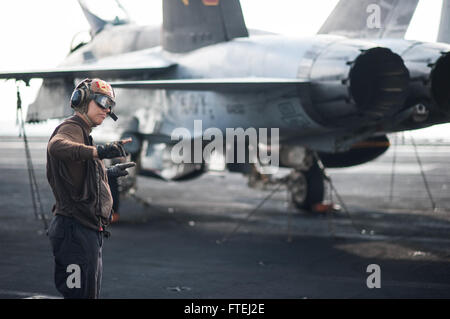 Mare Mediterraneo (ott. 31, 2014) Aviazione meccanico strutturale Airman Londra Olan, da Toledo, Ohio, sorge da un osservatore di sicurezza come un F/A-18C Hornet, attaccato al "Golden guerrieri" di Strike Fighter Squadron (VFA) 87, conduce una bassa potenza accendere il ponte di volo della portaerei USS George H.W. Bussola (CVN 77). George H.W. Bush, homeported a Norfolk, Virginia, sta conducendo operazioni navali negli Stati Uniti Sesta flotta area di operazioni a sostegno degli Stati Uniti per gli interessi di sicurezza nazionali in Europa. Foto Stock