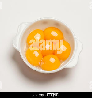 Sei materie i tuorli in una ciotola bianco Foto Stock