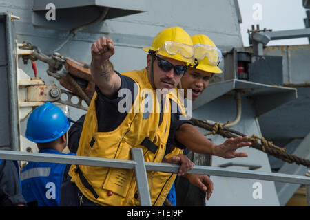 Mare Mediterraneo (nov. 16, 2014) - di Boatswain Mate 2a classe Alan Farthing, sinistra, da Grove City, Ohio, e di Boatswain Mate 3° di classe Dontrell Dorsett, da Fort Worth, Texas, dare istruzioni ai gestori di linea a bordo della USS Cole (DDG 67) durante un rifornimento in mare con la USNS Leroy Grumman (TAO 95). Cole, un Arleigh Burke-class guidato-missile destroyer homeported in Norfolk, sta conducendo operazioni navali negli Stati Uniti Sesta flotta area di operazioni a sostegno degli Stati Uniti per gli interessi di sicurezza nazionali in Europa. Foto Stock