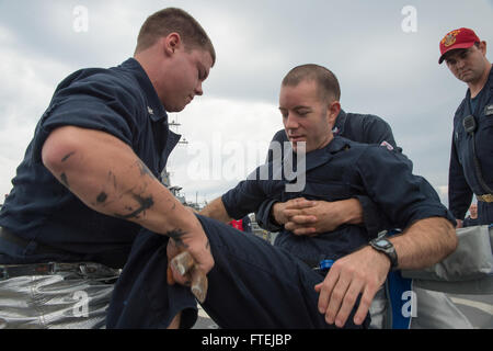 Mare Mediterraneo (nov. 21, 2014) - i marinai a bordo della USS Cole (DDG 67) rimuovere simulato un incidente durante un volo quarti trapano, nov. 21. Cole, un Arleigh Burke-class guidato-missile destroyer homeported in Norfolk, sta conducendo operazioni navali negli Stati Uniti Sesta flotta area di operazioni a sostegno degli Stati Uniti per gli interessi di sicurezza nazionali in Europa. Foto Stock