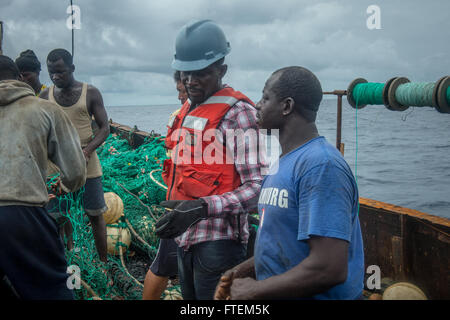 Oceano atlantico (feb. 23, 2015) in Ghana di un funzionario di polizia imbarcato a bordo i militari Sealift il comando congiunto del ad alta velocità a nave USNS Spearhead (JHSV 1) esegue una query a un pescatore locale durante una visita, scheda, ricerca e sequestro in evoluzione come parte dell Africa diritto marittimo di partenariato di esecuzione dal 23 febbraio, 2015. Punta di diamante è su una distribuzione programmata per gli Stati Uniti Sesta flotta area di operazioni a sostegno della collaborazione internazionali di costruzione di capacità del programma di Partenariato Africa stazione. Foto Stock