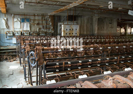 Arrugginimento macchinari abbandonati in giro del secolo la seta gettando fabbrica. Foto Stock