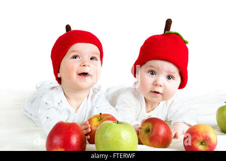 Due graziosi bambini giacente in cappelli sul morbido manto con mele Foto Stock