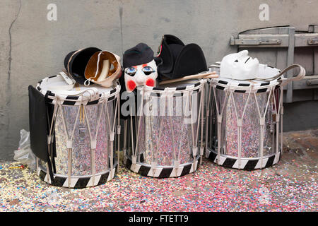 Tre tamburi sul lato della strada con le maschere sulla parte superiore in attesa per i loro proprietari durante il Carnevale di Basilea 2016 Foto Stock