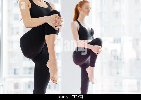 Primo piano di due attraenti le giovani donne in piedi e gambe di stiramento Foto Stock