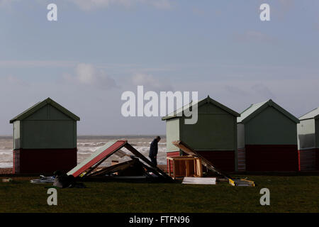 Brighton, Regno Unito. 28 Mar, 2016. Un passante guarda alla spiaggia danneggiato capanne in Hove dopo il vento e la pioggia hanno portato dalla tempesta Katie ha flagellato la costa a Brighton, East Sussex, Regno Unito lunedì 28 marzo, 2016. La BBC di segnalazione sono "storm Katie ha visto raffiche fino a 105mph percosse in Inghilterra e in Galles, con numerosi voli deviato da aeroporti e grandi ponti chiuso'. Credito: Luca MacGregor/Alamy Live News Foto Stock