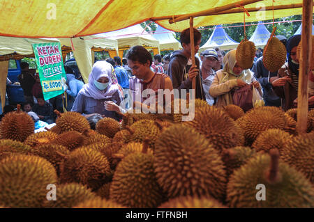 Jombang, Indonesia. 27 Mar, 2016. Alcune persone acquistano durian durante un festival chiamato 'kenduren Wonosalam'. In questo festival vi è un interessante vista quando un durian gettato in aria e decine di persone a scrambling di cattura lui? Questo spettacolo unico può essere visto ogni anno nel villaggio chiamato Wonosalam, Jombang, East Java, Indonesia, durante il festival. Coloro che cattura l'durian ha il diritto di mangiare sul posto o di portarlo a casa da condividere con la famiglia. Credito: Luhur Wijaya/Pacific Press/Alamy Live News Foto Stock