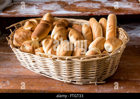 Cesto in Vimini riempito con freschi assortiti croccante bianca rotoli sul display per la vendita in un forno Foto Stock