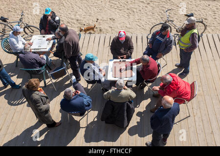 Gli uomini anziani gioca domino a Barceloneta Beach a Barcellona Foto Stock