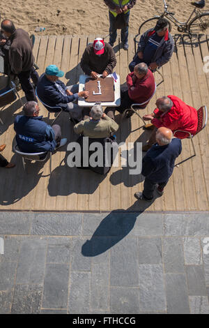 Gli uomini anziani gioca domino a Barceloneta Beach a Barcellona Foto Stock