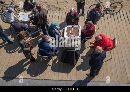Gli uomini anziani gioca domino a Barceloneta Beach a Barcellona Foto Stock