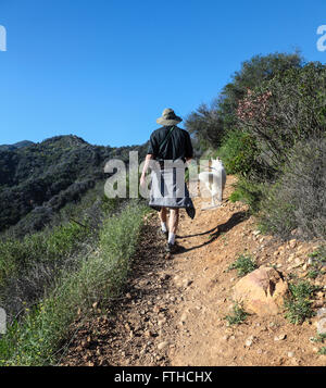 Escursionista e cane a camminare fino il Rivas Canyon Trail in Santa Monica Mountains, a cui si accede dal Gateway Temescal Park Foto Stock