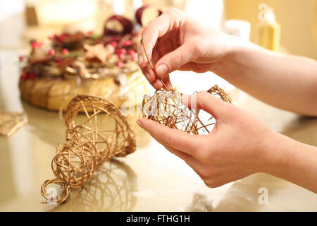 Fabbricazione di giocattoli decorazioni in legno, campane. Albero di natale toy campane bastoni intrecciato. Le decorazioni di Natale Foto Stock