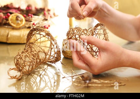 Fabbricazione di giocattoli decorazioni in legno, campane. Albero di natale toy campane bastoni intrecciato. Le decorazioni di Natale Foto Stock